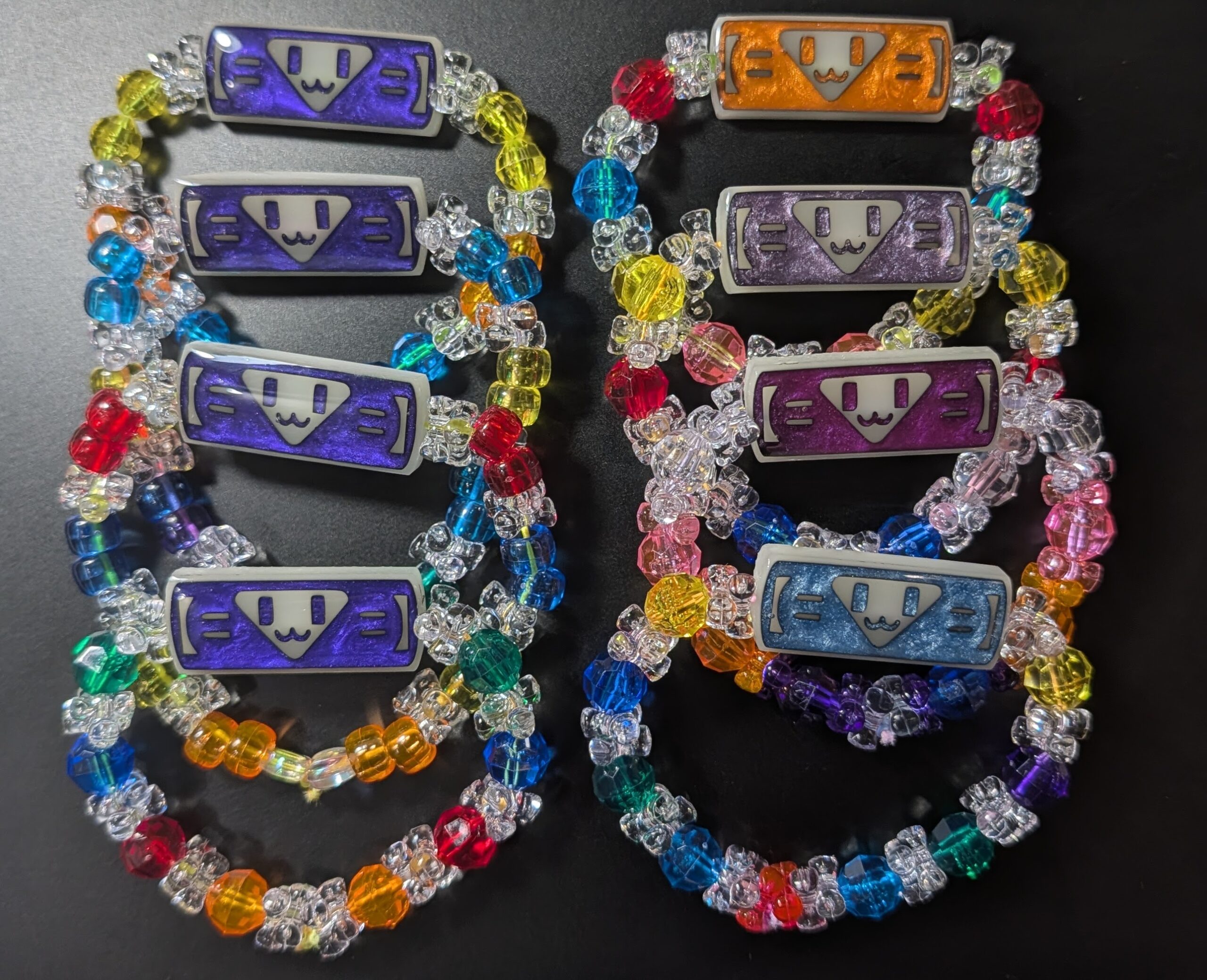Eight finished kandi bracelets with colorful beads and shimmering smiley charms