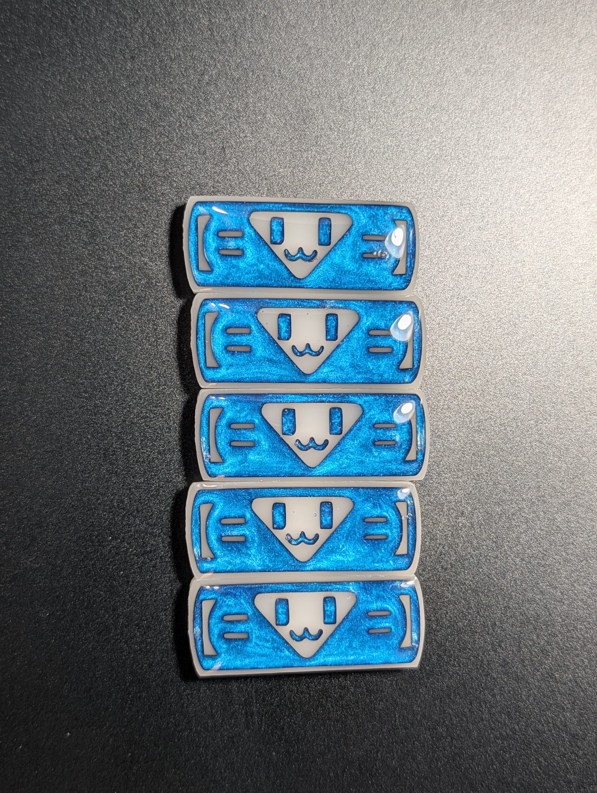 Five bright blue shimmering smiley charms